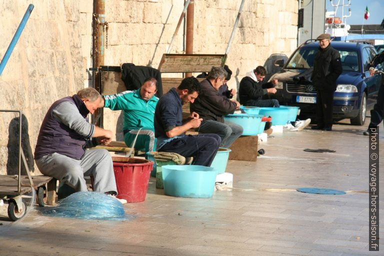Pêcheurs travaillant à leurs lignes sur le port de Monopoli. Photo © Alex Medwedeff
