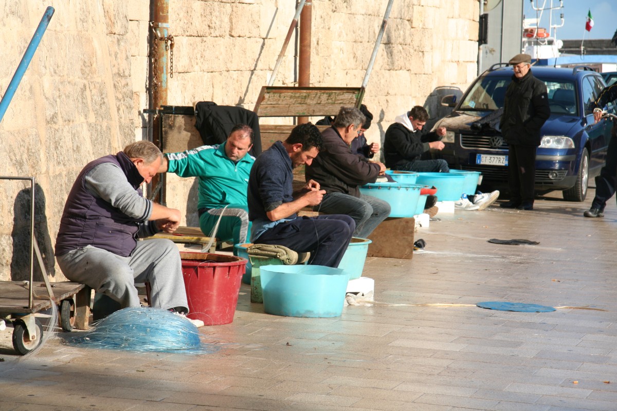 Pêcheurs travaillant à leurs lignes sur le port de Monopoli. Photo © Alex Medwedeff