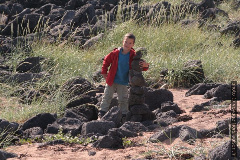 Nicolas avec un cairn de galets de lave au bord de la baie Búðavík. Photo © Alex Medwedeff