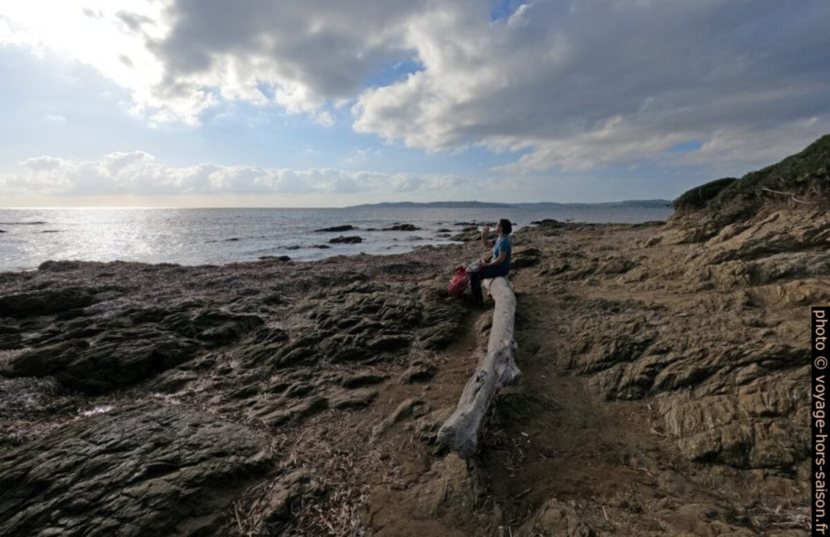 Alex assise sur un tronc échoué sur la côte nord de la Pointe des Sardinaux. Photo © André M. Winter