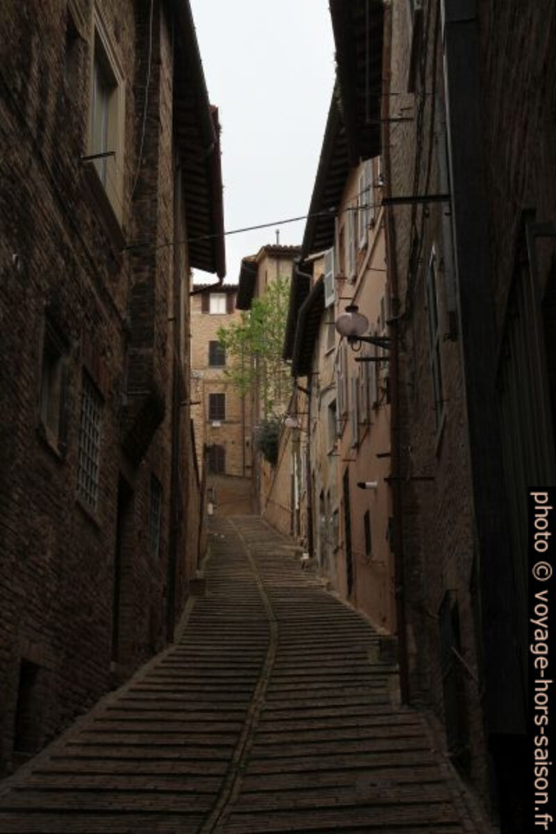 Une ruelle sombre en pente à Urbino. Photo © Alex Medwedeff
