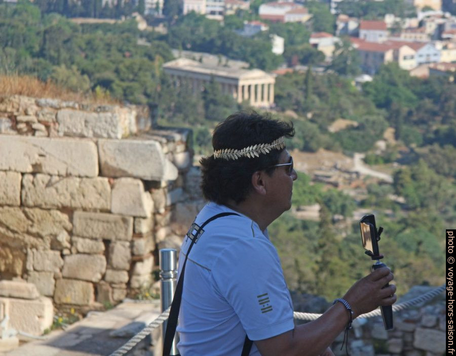 Touriste avec perche selfie et avec couronne de laurier doré en plastique. Photo © André M. Winter