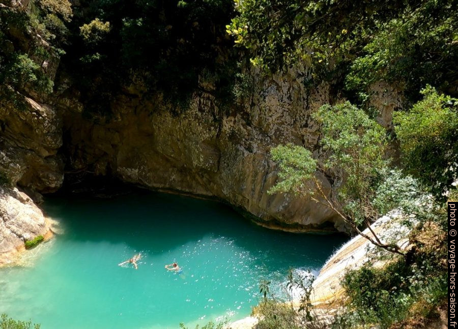 Vue plongeante sur des nageurs dans le lac sous la grande cascade de Polylimino. Photo © André M. Winter